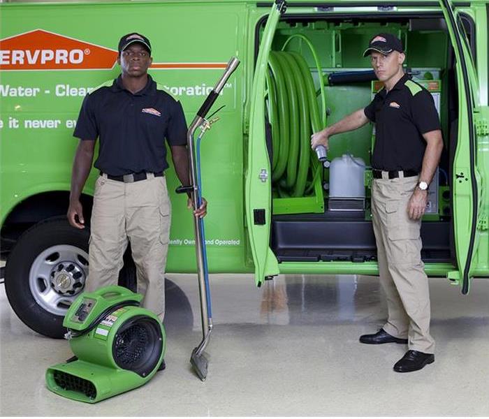 Two techs standing next to a SERVPRO Van 